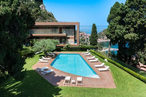 een huis met een zwembad en ligstoelen bij Mon Repos Avenir in Taormina