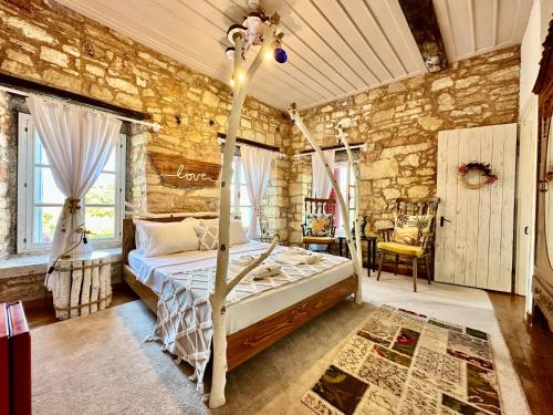 1 dormitorio con cama y pared de piedra en Marissa Boutique Hotel, en Cesme