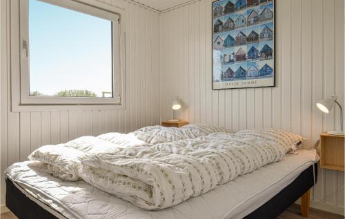 スナーヴィグにあるBeautiful Home In Ringkbing With Wifiの窓付きの客室の大型ベッド1台分です。