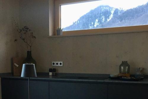 a kitchen with a window with a view of a mountain at KampenZeit Loft mit traumhaftem Panoramablick in Aschau im Chiemgau