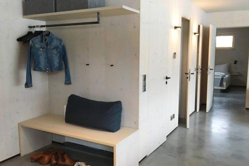 a room with a bench and a denim jacket hanging on a wall at KampenZeit Loft mit traumhaftem Panoramablick in Aschau im Chiemgau