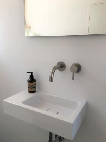 a white sink in a bathroom with a mirror at KampenZeit Loft mit traumhaftem Panoramablick in Aschau im Chiemgau