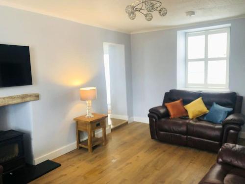 un salon avec un canapé et une table avec une lampe dans l'établissement Delightful Dog Friendly Seaside Cottage in Shaldon Devon, à Shaldon