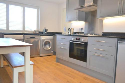 a kitchen with stainless steel appliances and a table at Delightful Dog Friendly Seaside Cottage in Shaldon Devon in Shaldon