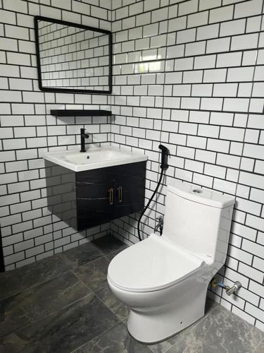 a bathroom with a white toilet and a sink at Big Dreams Garden Stay in Tanah Rata