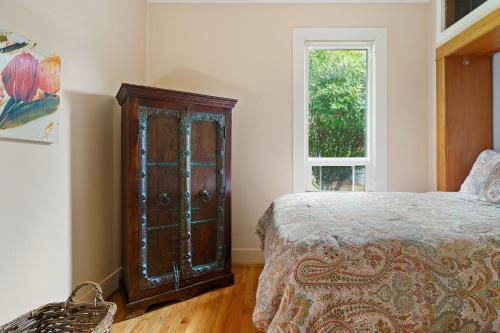 a bedroom with a bed and a wooden cabinet at Geneva Retreat in Bellingham