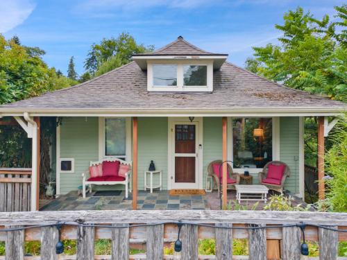 a green house with pink chairs and a porch at Geneva Retreat in Bellingham