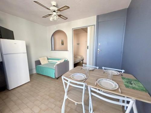 une salle à manger avec une table et des chaises et une chambre dans l'établissement Confortable Studio cabine - accès plage- vue mer 4TVP38, au Barcarès
