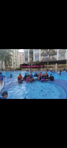 un grupo de personas en una piscina en Homestay Anak Kito@Teluk Kemang Port Dickson, en Port Dickson