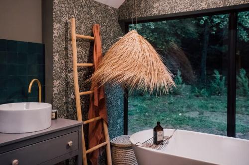 Casa Friendly avec sa piscine chauffée … في Les Croix Chemins: حمام مع حوض ومغسلة ونافذة
