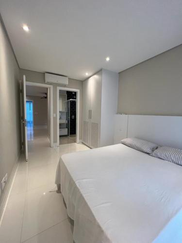 - une chambre avec un grand lit blanc dans l'établissement MINHA CASA NA PRAIA, à Riviera de São Lourenço