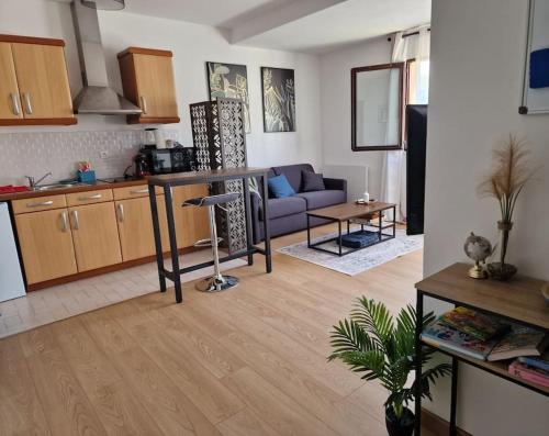 une cuisine et un salon avec une table et un canapé dans l'établissement Charmant appartement plein centre 250m de la gare 30mn de Paris, aux Mureaux