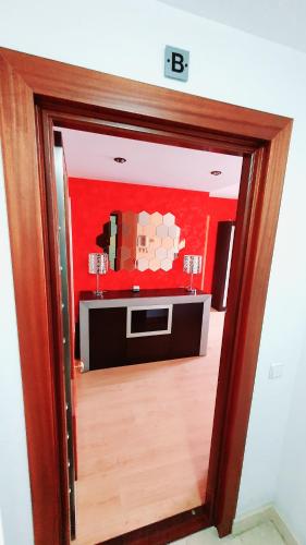 eine Tür in ein Zimmer mit einer roten Wand in der Unterkunft Diana´s Luxury Apartment in Torrejón de Ardoz