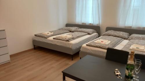 een kleine kamer met 2 bedden en een tafel bij CozyNite Premium Apartment Hauptbahnhof 1+2 in Wenen