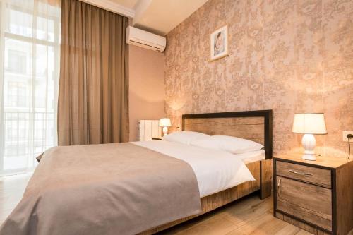 a bedroom with a large bed and a large window at The Urban Retreat in Tbilisi City