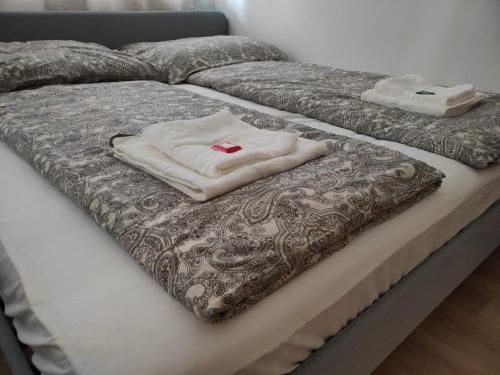 een bed met twee witte handdoeken erop bij CozyNite Premium Apartment Hauptbahnhof 1+2 in Wenen