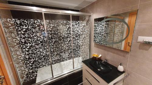 a bathroom with a shower with a black and white pattern at Diana´s Luxury Apartment in Torrejón de Ardoz