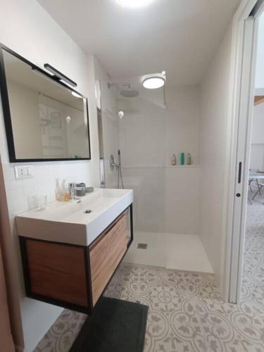 a white bathroom with a sink and a mirror at Sull'arco della Gnostra in Noci