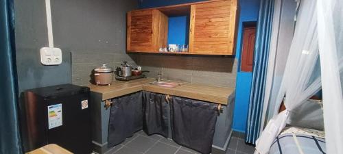 una pequeña cocina con fregadero y nevera. en Studio Standard - AMI APPARTHOTEL, en Tôlagnaro