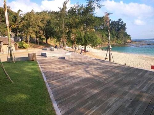 a wooden deck next to a beach with the ocean at Studio Standard - AMI APPARTHOTEL in Tôlagnaro