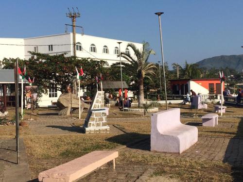 a park with benches in front of a building at Studio Standard - AMI APPARTHOTEL in Tôlagnaro