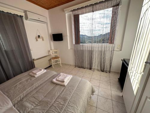 a bedroom with a bed with two towels on it at Bacchus Villa in Archea Pissa