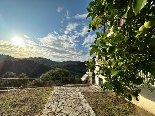 a stone pathway leading to a house with the sun in the sky at Bacchus Villa in Archea Pissa