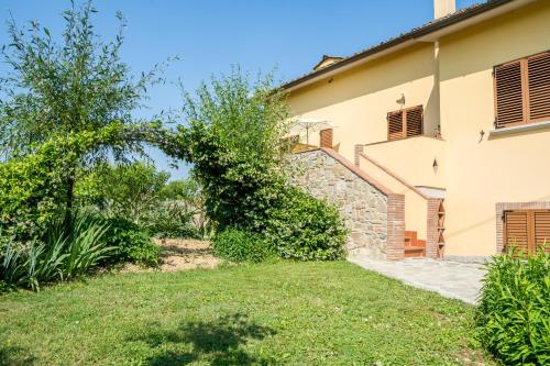 a house with a green yard next to a building at B&B Maesta' Di Cudino in Arezzo