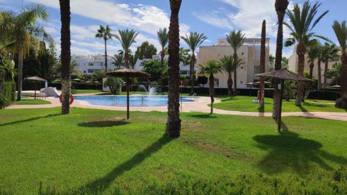 einen Park mit Palmen und einem Pool in der Unterkunft Discover perfect beach Apartment, only 300m away in Vera