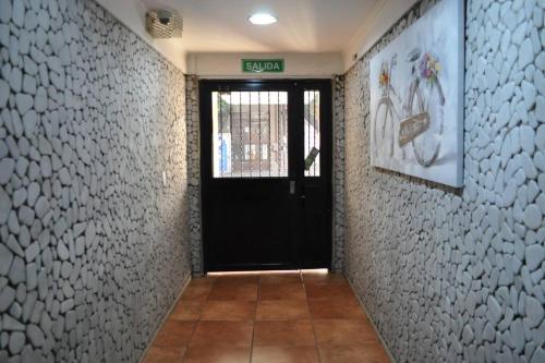 un pasillo con una puerta negra en una pared blanca en Alojamiento en pleno centro en Mendoza
