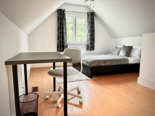 Un dormitorio con una cama, un escritorio y una mesa. en Cottage Retreat on 11 Acres, en Flesherton