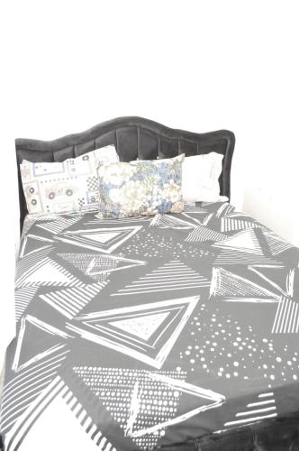a bed with a black and white comforter and pillows at Professional Studio Appartment in Bobigny