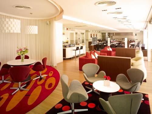 a restaurant with tables and chairs and a red rug at NH Bangkok Asoke in Bangkok