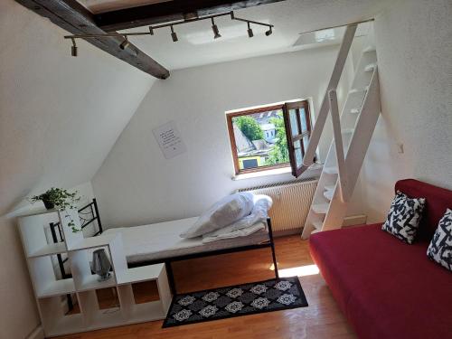 sala de estar con sofá rojo y escaleras en Saaler Pfandl Ferienwohnung zentral gelegen, en Saal