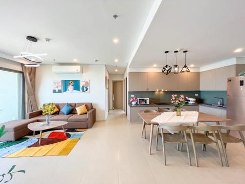 een keuken en woonkamer met een bank en een tafel bij THE SÓNG Apartment Vũng Tàu - Trinh's House in Vung Tau