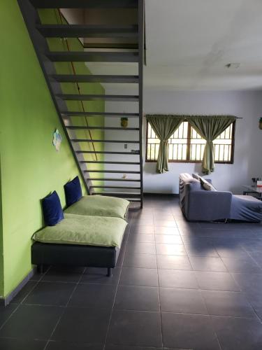 een woonkamer met een bed en een bank bij Sue's Place in Paramaribo