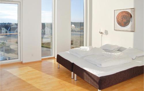 HavnebyにあるAmazing Apartment In Rm With 3 Bedrooms And Wifiの大きな窓付きの客室のベッド1台分です。
