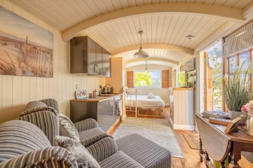 a living room with two couches and a kitchen at Relaxing Retreat - The Shepherds Hut - Hot Tub in White Waltham