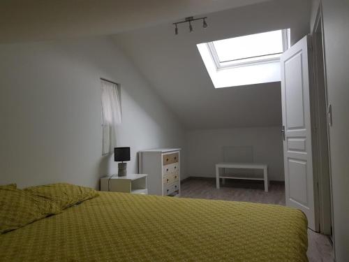 a bedroom with a bed and a skylight at Gîte à la campagne in Manglieu