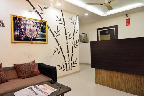 uma sala de estar com um sofá e uma ventoinha de tecto em hotel royal apple em Ahmedabad