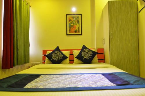 um quarto com uma cama com paredes amarelas e cortinas verdes em hotel royal apple em Ahmedabad