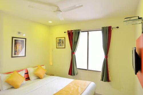 um quarto com uma cama e uma grande janela em hotel royal apple em Ahmedabad