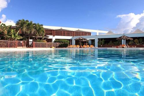 a large swimming pool in front of a hotel at Le Colibri des Alizés in Saint-François