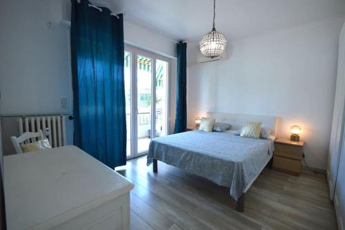 a bedroom with a bed with a blue blanket and a window at Le Madrilien & Terrasse & Clim & 400M Croisette in Cannes