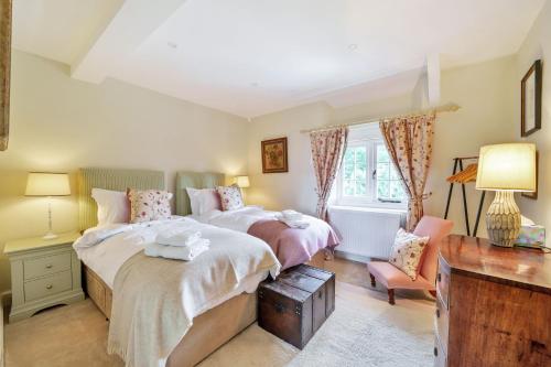 sypialnia z 2 łóżkami i oknem w obiekcie Cosy Cottage w mieście Dorchester