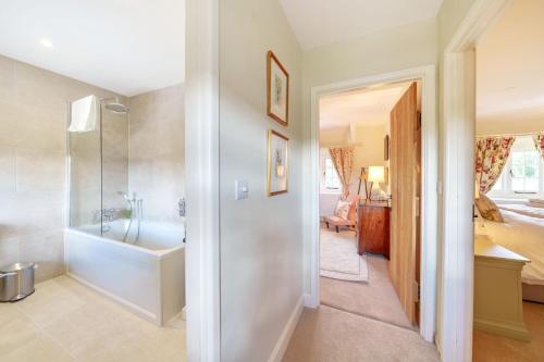 a bathroom with a shower and a tub and a sink at Cosy Cottage in Dorchester