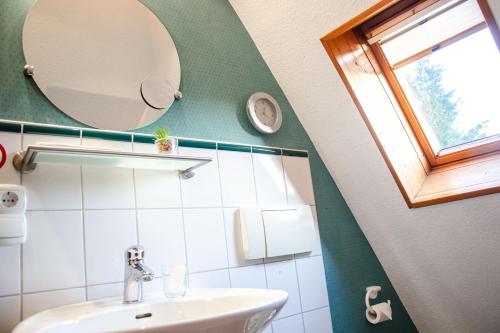 baño con lavabo, espejo y ventana en Weitblick-Loft mit Terrasse, en Rostock