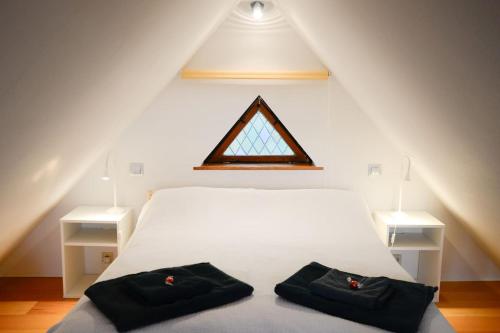 a bedroom with a white bed with two black bags on it at Weitblick-Loft mit Terrasse in Rostock