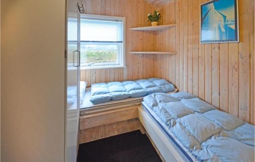 Nørre VorupørにあるNice Home In Thisted With 3 Bedrooms, Sauna And Wifiのベッド2台と窓が備わる客室です。