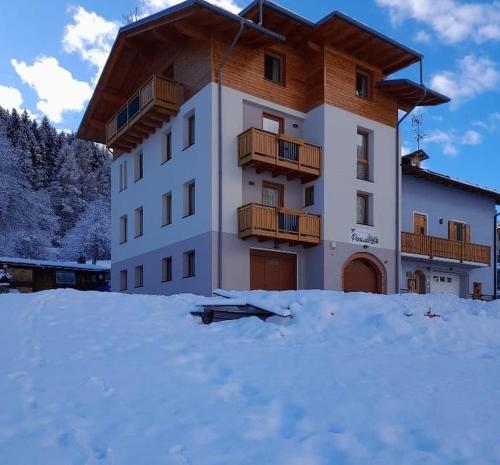 a building with a balcony in the snow at Casa Penasa Appartamento 1 in Commezzadura